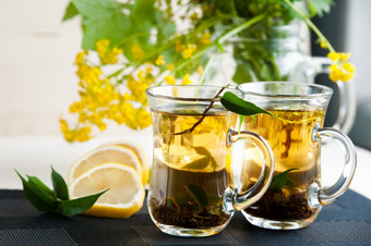 两个透明的杯与茶绿色黑色的Herbal茉莉花茶与柠檬和姜主题茶烹饪茶包装食物生产餐厅业务