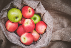 前视图红色的苹果绿色苹果篮子封面与棕色（的）粗麻布背景纹理