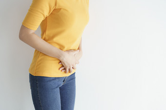 年轻的亚洲<strong>女人</strong>有痛苦的胃痛白色backgroundchronic胃炎腹部腹胀概念