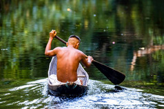 本地的部落男人。游泳亚马逊热带雨林手工制作的船本地的部落男人。亚马逊热带雨林手工制作的船