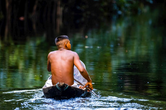本地的部落男人。游泳亚马逊热带雨林手工制作的船本地的部落男人。亚马逊热带雨林手工制作的船