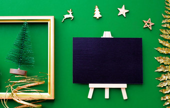 黑板上前视图与黄金圣诞节和新一年装饰点缀的东西绿色纸backgroundcelebrate照顾问候cardmock为显示设计
