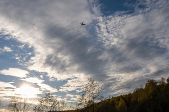 轮廓<strong>大飞机</strong>对美丽的多云的天空在秋天森林