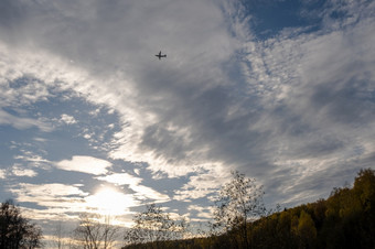轮廓<strong>大飞机</strong>对美丽的多云的天空在秋天森林