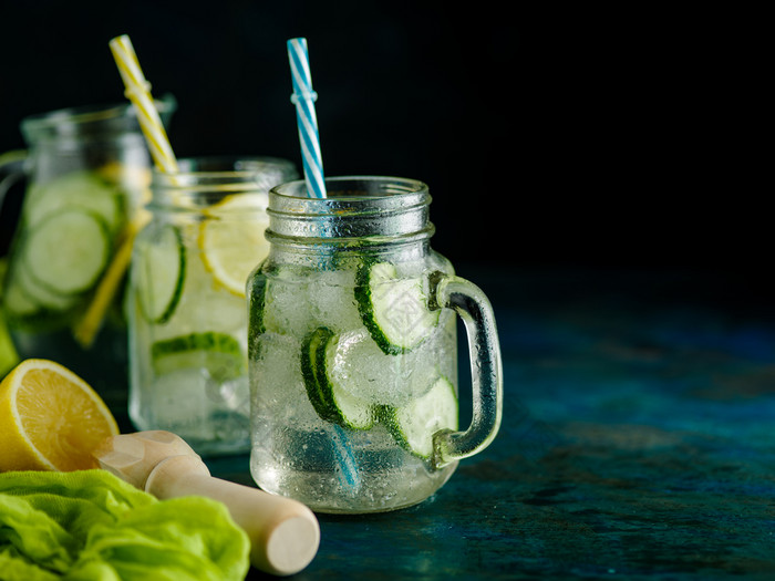 新鲜的夏天喝健康的排毒碳酸水与柠檬和黄瓜梅森Jar在黑暗背景健康的食物概念排毒饮食