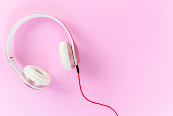 粉红色的耳机和红色的电缆<strong>柔和</strong>的颜色粉红色的<strong>背景音乐</strong>概念空白复制空间