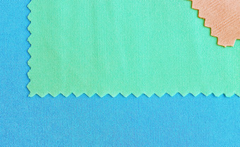 蓝色的和绿色块纺织样品特写镜头可以使用织物织构背景与空间为复制纺织纹理背景