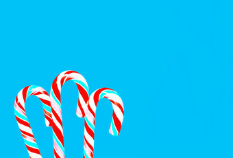 条纹红色的和绿松石棒棒糖糖果拐杖蓝色的背景问候卡假期背景与空间为复制节日蓝色的背景与棒棒糖