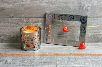 金属框架与铁线莲水果和烛台与橙色蜡烛粗糙的灰色的木背景与礼物丝带灰色的和橙色仍然生活