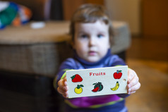 小女孩显示董事会与水果画孩子玩与木水果玩具健康的吃概念上的比喻与画水果
