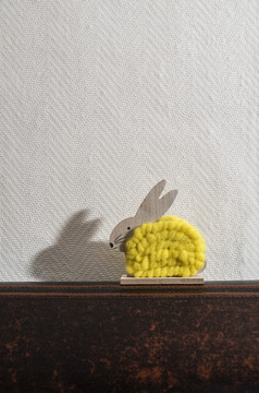 黄色的复活节兔子前面白色墙房间兔子装饰和白色壁纸背景影子兔子的墙木兔子数字形状和黄色的纱极简主义概念