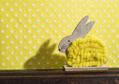 黄色的复活节兔子前面墙点房间兔子装饰和黄色的壁纸背景点影子兔子的墙木兔子数字形状和黄色的纱极简主义概念