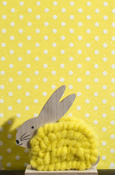黄色的复活节兔子前面墙点房间兔子装饰和黄色的壁纸背景点影子兔子的墙木兔子数字形状和黄色的纱极简主义概念