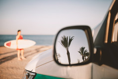 反射棕榈树的外镜子的海滩