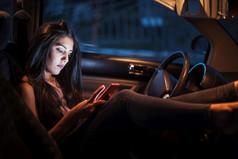 女人内部车使用她的智能手机看虽然的窗口女人内部车使用她的智能手机