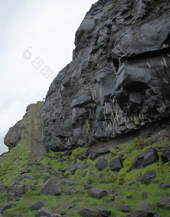 垂直景观图像湿黑色的彩色的岩石墙火山起源后的雨与石头楼梯的左一边的变幻莫测岛的法罗岛屿光荣的风景的法罗语明信片主题