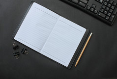 前视图笔记本和铅笔键盘与配件放置黑色的桌子上办公室和有复制空间概念你的工作
