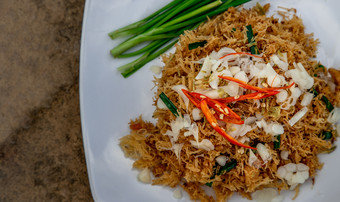 亚洲吃食物跟grob甜蜜的和酸脆皮面条使从泰国大米面条与甜蜜的和酸酱汁白色板甜蜜的酸脆皮大米面条关闭
