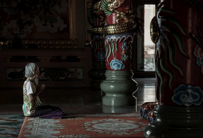 春武里泰国2月高级女人坐着祈祷支付尊重佛雕像的wihan你sathitphrachaloem三潮父亲焦点和模糊