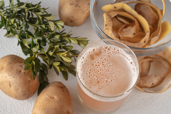 汁玻璃与土豆土豆白色背景视图从以上汁玻璃与土豆土豆白色背景
