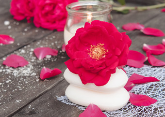 自然化妆品肥皂与红色的玫瑰和热蜡烛的黑暗木背景的水疗中心自然化妆品肥皂与红色的玫瑰和热蜡烛黑暗木背景