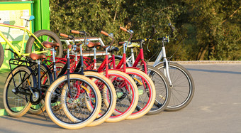 集<strong>团</strong>色彩斑斓的自行车停车很多站在一起的沥<strong>青</strong>的公园在的明亮的射线的设置太阳集<strong>团</strong>色彩斑斓的自行车停在一起停车很多特写镜头