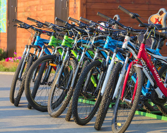 集<strong>团</strong>色彩斑斓的自行车停车很多站在一起的沥<strong>青</strong>的公园在的明亮的射线的设置太阳集<strong>团</strong>色彩斑斓的自行车停在一起停车很多特写镜头