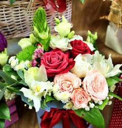 特写镜头美丽的花束新鲜的红色的粉红色的和白色玫瑰布鲁姆对柳条篮子模糊美丽的花束各种各样的花与中央作文红色的玫瑰