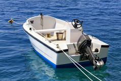 钓鱼电动机船锚定的清晰的绿松石水域的爱奥尼亚海与提高了引擎洛特拉基希腊电动机船锚定的清晰的水域的爱奥尼亚海