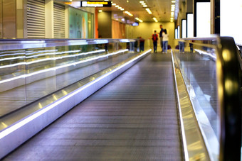 的明亮的紫色的运输车道的机场携带家庭乘客和他们的行李模糊沿着的走廊的明亮的运输车道的机场携带乘客模糊