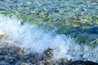美丽的海波与透明的和绿松石泡沫卵石海滩图像与复制空间飞溅纯绿松石海波卵石的海滨