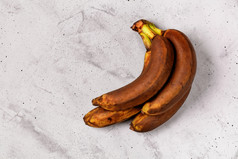 丑陋的棕色（的）成熟的香蕉灰色的混凝土背景平躺图像与复制空间丑陋的成熟的香蕉谎言灰色的混凝土背景
