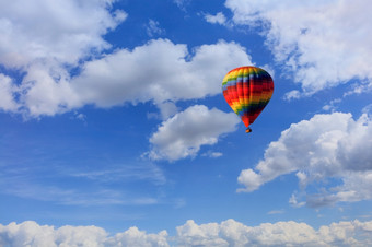 飞行美丽的五彩缤纷的热空气气球与篮子游客的背景的蓝色的天空以上的白色云复制空间马特里五彩缤纷的热空气气球提出了篮子与游客的蓝色的天空在白色云