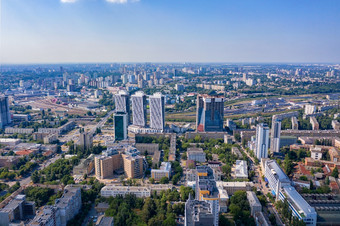 空中摄影住宅区域基辅与视图的铁路站和新摩天大楼下建设空中视图城市摄影复制空间空中摄影阳光照亮城市住宅区域和绿色公园的夏天蓝色的阴霾