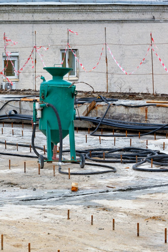 大建设喷砂机绿色颜色对的背景的工作区域为的修复的巷道垂直图像复制空间建设喷砂机的工作网站为的处理金属结构垂直图像