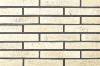 的背景和纹理的墙是排与光米色长方形的砖与甚至水泥关节的墙面对与光米色长方形的砖墙纹理与光滑的水泥关节