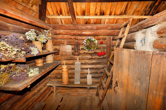 的巨大的木货架上的前庭老农村小屋各种各样的木家庭项目菜主轴灯和束干草本植物是存储的实用程序房间和的入口大厅老农村小屋是填满与各种各样的家庭木餐具