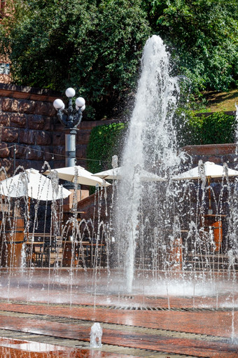 美丽的流水飞机的城市喷泉对的背景夏天咖啡馆阳光明媚的公园垂直图像城市喷泉对的背景夏天咖啡馆阳光明媚的公园