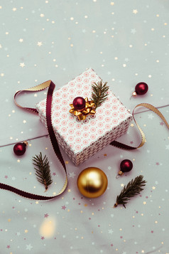 包装圣诞节礼物成盒子装修使用红色的丝带红色的圣诞节球和松树枝粉红色的织物的背景模糊圣诞节灯平自顶向下作文
