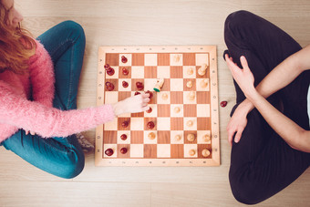 女孩和男孩玩国际象棋首页女孩移动她的一块和捕捉她的对手rsquo骑士青少年坐着地板上视图从以上复制空间为文本的前和<strong>底图</strong>像