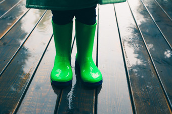 特写镜头腿孩子站玄关穿绿色<strong>长筒</strong>靴和雨衣雨<strong>靴子</strong>明亮的绿色颜色