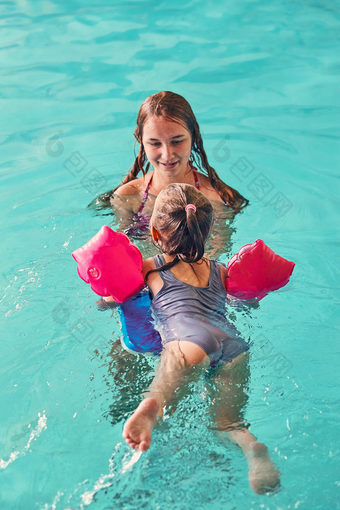 年轻的女人教学游泳她的年轻的妹妹和玩与她的游泳池坦诚的人真正的时刻真实的的情况下