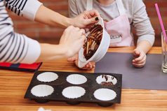 小女孩和她的妈妈把的融化了巧克力和可可蛋糕家庭采取部分烘焙车间烘焙类为孩子们有抱负的小厨师学习烹饪结合和激动人心的准备成分真正的人真实的的情况下