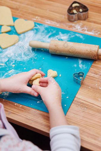 小女孩切割的面团心形状为的饼干孩子采取部分烘焙车间烘焙类为孩子们有抱负的小厨师女孩学习烹饪结合和激动人心的准备成分真正的人真实的的情况下