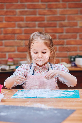 小女孩吃的糖衣糖左后烘焙饼干孩子采取部分烘焙车间烘焙类为孩子们有抱负的小厨师学习烹饪结合和激动人心的准备成分真正的人真实的的情况下