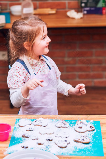 小女孩享受她的烤饼干装修饼干与色彩斑斓的撒上和糖衣糖孩子采取部分烘焙车间烘焙类为孩子们有抱负的小厨师学习烹饪结合和激动人心的准备成分真正的人真实的的情况下