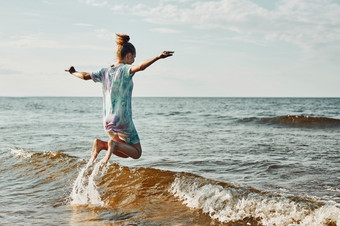 女孩享受海跳在波<strong>支出</strong>免费的时间在海海滩日落在夏天假期女孩享受海跳在波<strong>支出</strong>免费的时间在海海滩在夏天假期