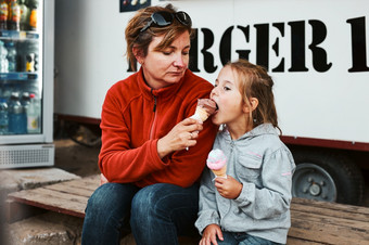 妈妈。和她的女儿吃冰奶油坐着一步前面食物卡车在夏天假期妈妈。和她的女儿吃冰奶油坐着一步前面食物卡车