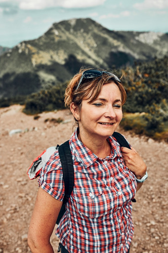 微笑快乐女人与背包徒步旅行山积极支出夏天假期走山站山路径mugo松山峰后面她的微笑快乐女人与背包徒步旅行山积极支出夏天假期