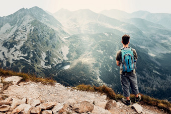 年轻的男人。与背包徒步旅行山积极<strong>支出</strong>夏天假期后视图男人。站的前山欣赏山景观全景年轻的男人。与背包徒步旅行山积极<strong>支出</strong>夏天假期